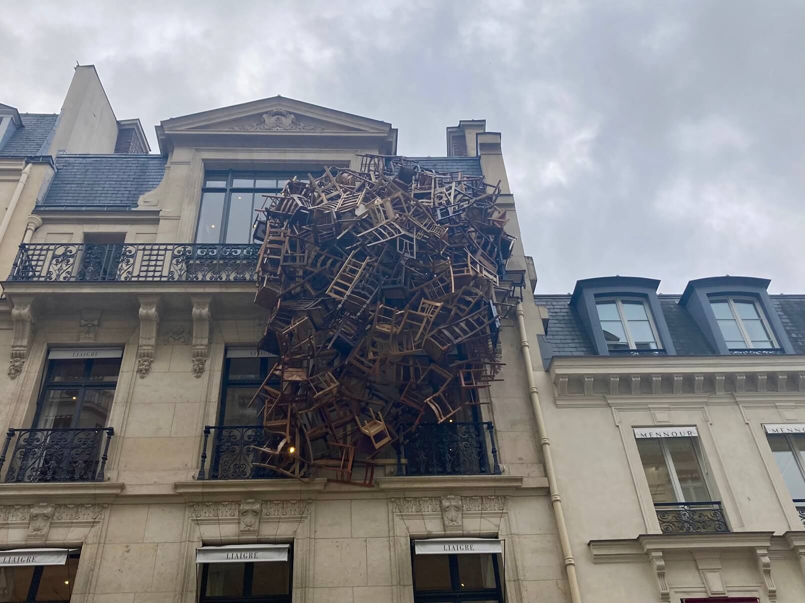 パリ最新情報「街がアートになるパリ。パリのビルにぶら下がる椅子は何？」