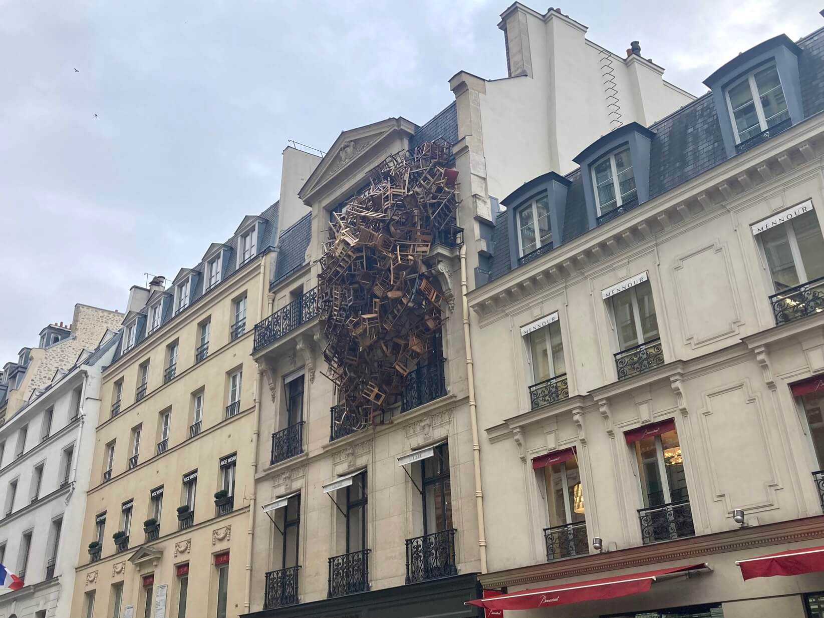 パリ最新情報「街がアートになるパリ。パリのビルにぶら下がる椅子は何？」